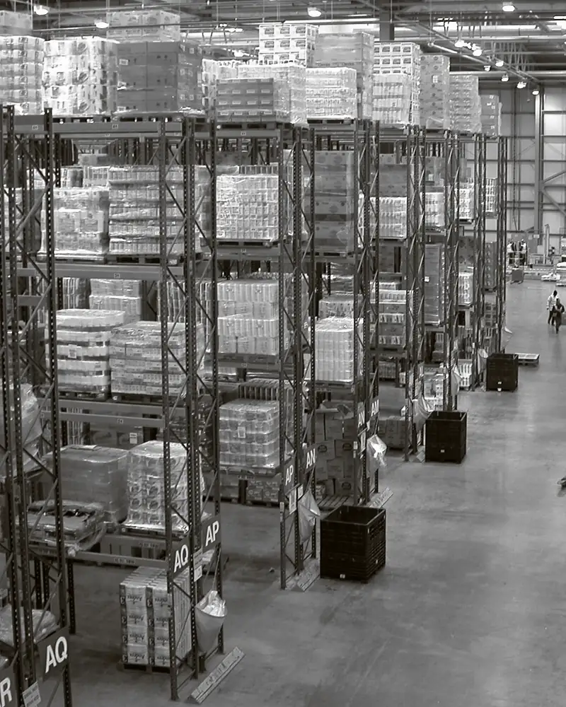 Tall pallet racking loaded with shrink-wrapped pallets inside a distribution warehouse